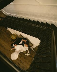 a bride and groom laying down on the stairs