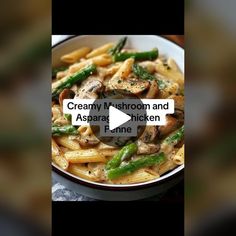 a bowl filled with pasta covered in mushrooms and asparagus