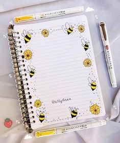 an open notebook with bees and flowers on it