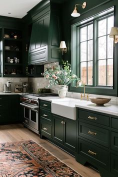 a kitchen with green cabinets and an area rug in front of the sink, window