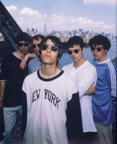 a group of young men standing next to each other in front of a body of water