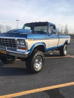 a blue and white truck parked in a parking lot