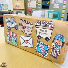 a cardboard box with stickers on it sitting on top of a table in a classroom