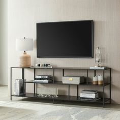 a flat screen tv mounted to the side of a wall next to a shelf filled with books