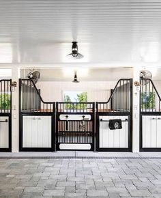 the inside of a horse stable with white and black doors