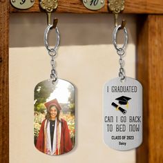 two key chains hanging from hooks on a wall with an image of a graduate and the words, i graduated can i go back to bed now class of 2012