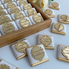 there are many gold and white place cards on the table