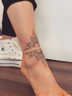 a woman's foot with a tattoo on the side of her leg and an arrow