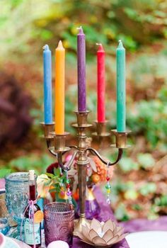 a candelabra filled with candles sitting on top of a purple table cloth