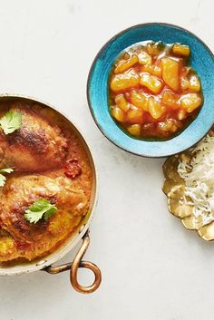 two bowls filled with food sitting on top of a white table next to each other