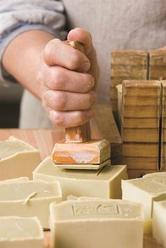 a person using a knife to cut cheese