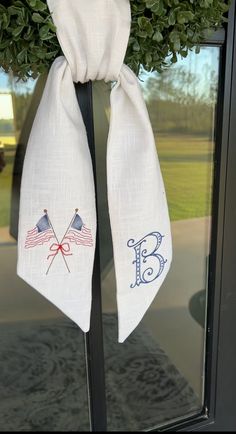 two white towels hanging from a door with an american flag and crossed flags on them