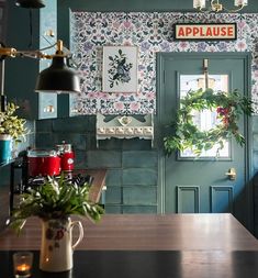 a kitchen with green walls and floral wallpaper