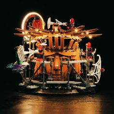 a model of a building made out of legos on a wooden table with lights around it