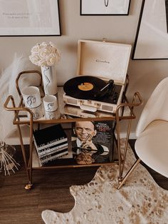 a record player sitting on top of a table next to a chair and other items