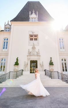 a woman standing in front of a large white building