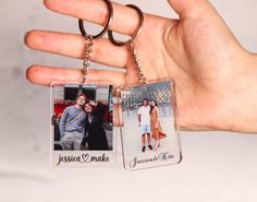 a hand holding two key chains that have photos on them and the words jesus made