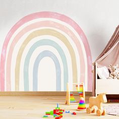 a child's bedroom with a rainbow painted on the wall and wooden toys scattered about