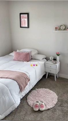 a white bed sitting in a bedroom next to a pink rug and two nightstands