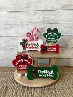 three wooden christmas signs sitting on top of a table