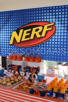 a table topped with lots of food next to a nerf sign