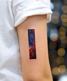 a woman's arm with a small space themed tattoo on the left side of her arm