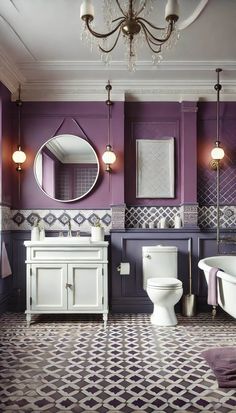 a bathroom with purple walls, white fixtures and a chandelier hanging from the ceiling