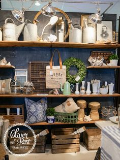 an assortment of items on shelves in a room with wooden crates and baskets, including teapots