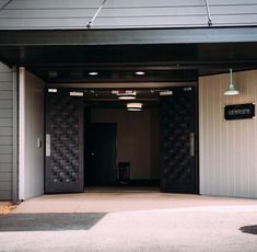 the entrance to an apartment building with two lights on each side and a sign above it