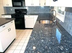 a kitchen with granite counter tops and white cabinets