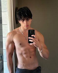 a shirtless man taking a selfie with his cell phone