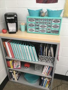 a book shelf with many books on top of it next to a coffee maker and other items