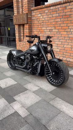 a black motorcycle parked in front of a brick building