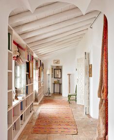 a room with many bookshelves and rugs on the floor