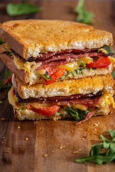 two sandwiches stacked on top of each other next to some greens and peppercorst