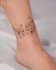 a close up of a person's foot with flowers on it and the bottom part of her leg