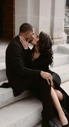 a man and woman sitting on steps kissing