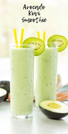 two glasses filled with kiwi smoothie next to sliced avocado on a table