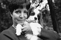 a woman holding a small dog in her arms