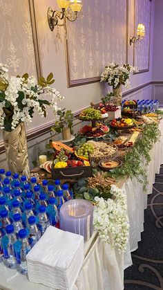 a buffet table filled with lots of food and water bottles on top of the tables