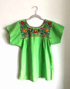 Beautiful vintage embroidered green, floral, Mexican blouse. The Mexican top is a beautiful green with brightly embroidered flowers on the front and back of the shirt.The blouse is lightweight and comfortable, perfect for the summer. It is made of 80% cotton and 20% polyester. The top is made in Mexico El Rebezo and is a size small.Please note a faint stain in the images and leather belt in not included.All items sold As Is. Any questions or concerns please contact me. Embroidered Crew Neck Blouse For Summer, Bohemian Green Top With Embroidered Hem, Bohemian Green Embroidered Hem Top, Spring Embroidered Green Blouse, Green Traditional Embroidered Top For Spring, Traditional Green Embroidered Top For Spring, Summer Green Blouse With Crew Neck, Traditional Green Blouse For Spring, Green Crew Neck Blouse For Summer