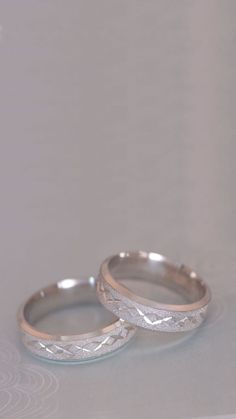 two wedding rings sitting on top of each other