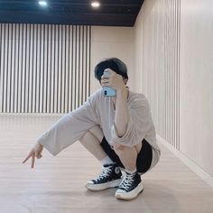 a young man taking a selfie with his cell phone in an empty room,