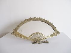 a decorative mirror sitting on top of a white table