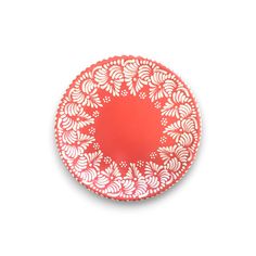 a red and white plate with an intricate design on the rim, against a white background