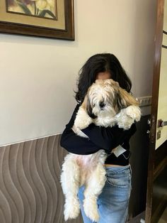 a woman holding a dog in her arms