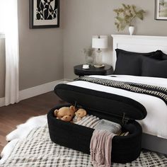 a black and white bedroom with an open suitcase on the bed, stuffed animals in it