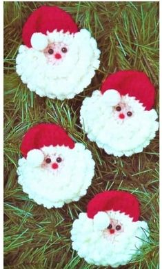 three crocheted santa clauss sitting in the grass with their eyes wide open