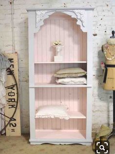 a white bookcase sitting next to a mannequin and dressmaker's dummy