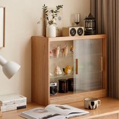 an open book on a desk next to a lamp